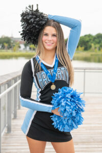 High school senior girl in a Hagerty High School cheerleader outfit posing for Khim Higgins Photography in Oviedo, Florida. 