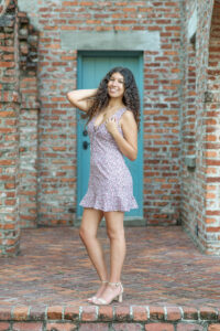 A lake mary senior girl standing in front of a brick wall.