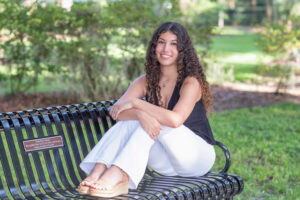 A lake mary senior girl sitting on a black bench.