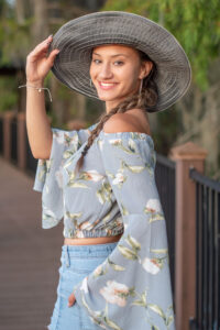 Senior girl portrait session wearing a hat and looking over her left shoulder at Orlando Senior Photographer.