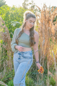 OHS senior girl is standing in a field of tall grass with Khim Higgins Photography.