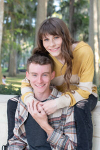 Timber Creek senior girl wraps her arm around her brother's neck as Orlando senior photographer takes their picture.