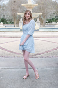 A lake mary senior girl in a short blue dress is swaying back and forth.