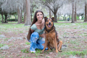 A senior girl from Oviedo High School and her dog is being photographed by Khim Higgins Photography.