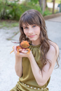 Timber Creek High school senior photo shoot with Khim Higgins Photography. A senior girl holding her bearded dragon sitting in a park.