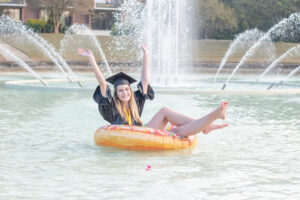 ucf graduate is sitting on a yellow float in the reflection pond