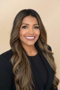 A beautiful brunette woman in a black jacket is smiling for a headshot photo with khim higgins photography in oviedo, florida.