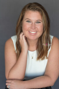 A woman in a white dress is sitting for her professional headshot in Oviedo, Florida with Khim Higgins Photography.