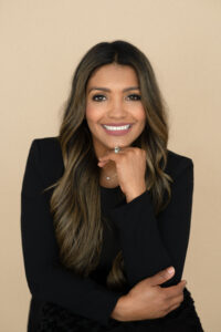 A beautiful brunette woman in a black jacket is smiling for a headshot photo with khim higgins photography in oviedo, florida.