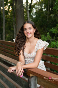 Oviedo senior girl at Lake Mills leaning on a wooden  boardwalk with Orlando Photographer, Khim Higgins.