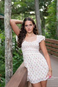 Oviedo senior girl leaning on a tree with her elbow looking at Khim Higgins photography.