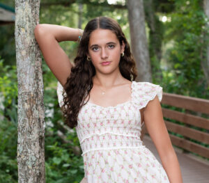 Oviedo senior girl leaning on a tree with her elbow looking at Khim Higgins photography.