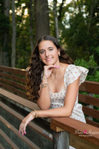 oviedo senior girl leaning on a wooden boardwalk as orlando senior photographer, khim higgins takes her photo.