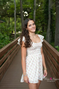 oviedo senior girl standing on a wooden boardwalk at Lake Mills while orlando senior photographer, khim higgins takes her photos.