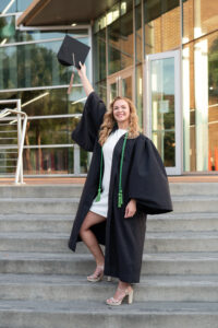 ucf grad standing on the stairs in front of the library