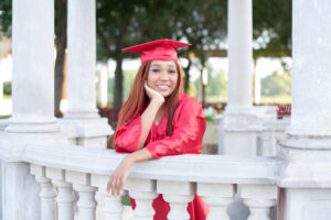 Senior girl wearing cap and gown at Cranes Roost Park