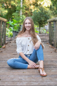 senior girl sitting on a boardwalk in Orlando