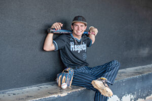 Orlando senior photographer captures teen boy posing with baseball gear for his senior portrait.