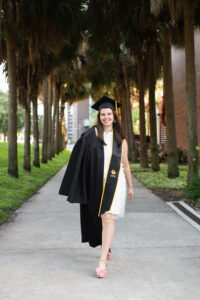 Senior girl in cap and gown walking