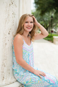 Smiling high school senior posing in a park at golden hour, photographed by an Orlando senior photographer.