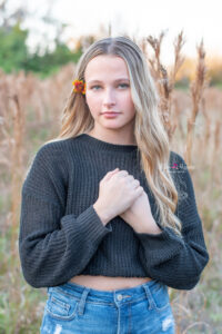 senior girl standing in a field of tall grass in Orlando