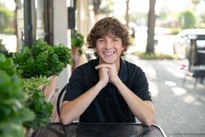 Lake Mary senior boy photographer taking senior pictures of a high school student at a cafe in Orlando.