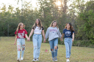 A group of senior girls in college shirts walking.