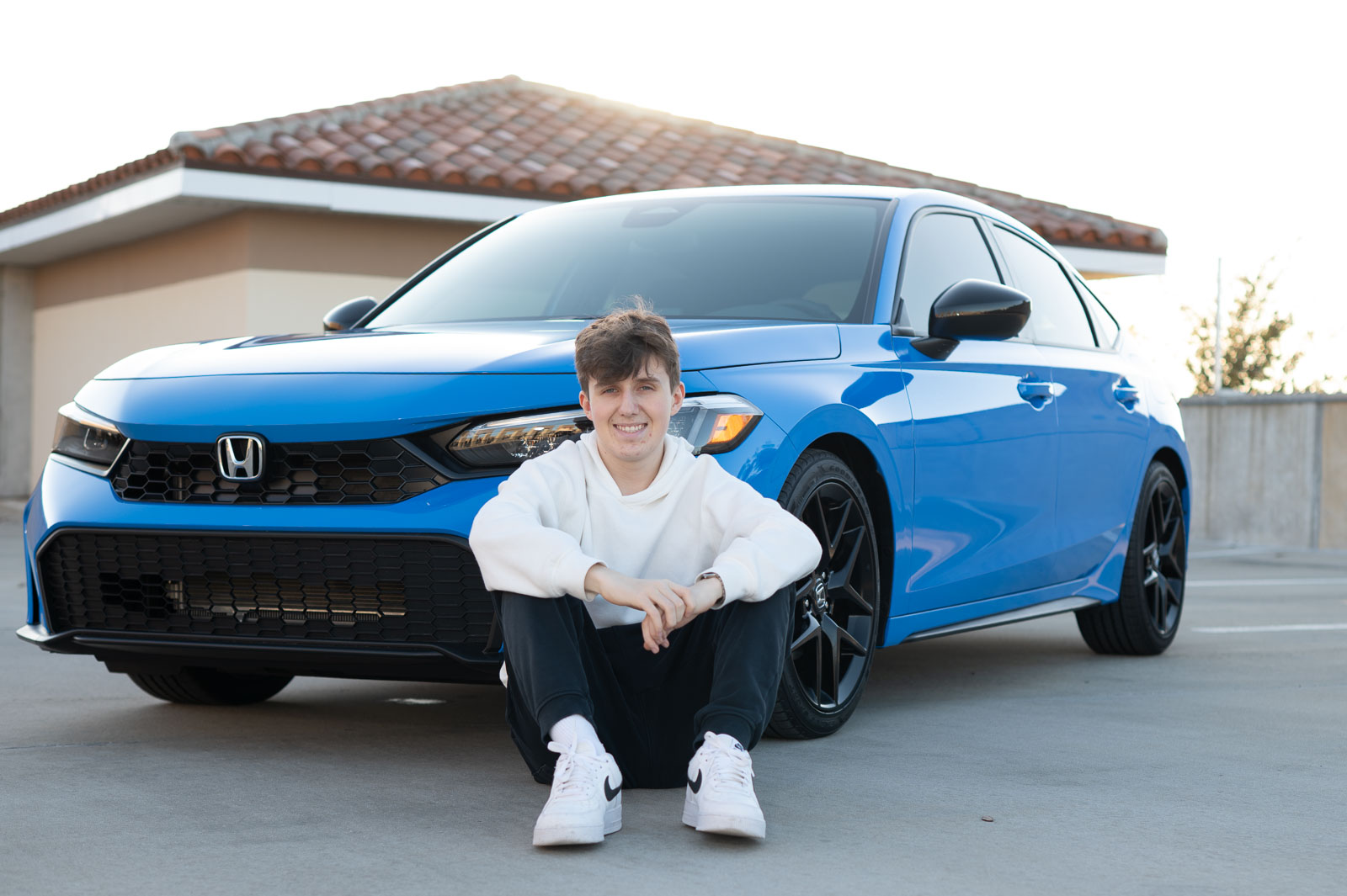 Senior boy posing confidently with his car during photo shoot by Winter Park senior photographer.