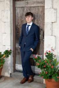 A winter park senior boy leans on a door.