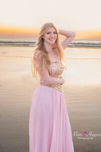 Senior girl smiling on the beach at sunrise in a flowy dress, Orlando senior photographer