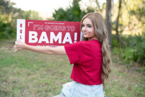 Senior girl holding a college banner
