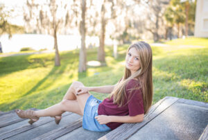 A high school senior posing along Park Avenue in Winter Park, Florida, during a golden hour portrait session with a professional senior photographer.