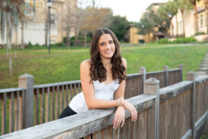 Full-body portrait of a Hagerty High School senior in her dance team uniform, smiling confidently for her senior photos.