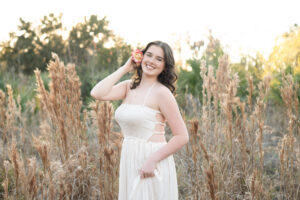 Senior girl in a field at golden hour.