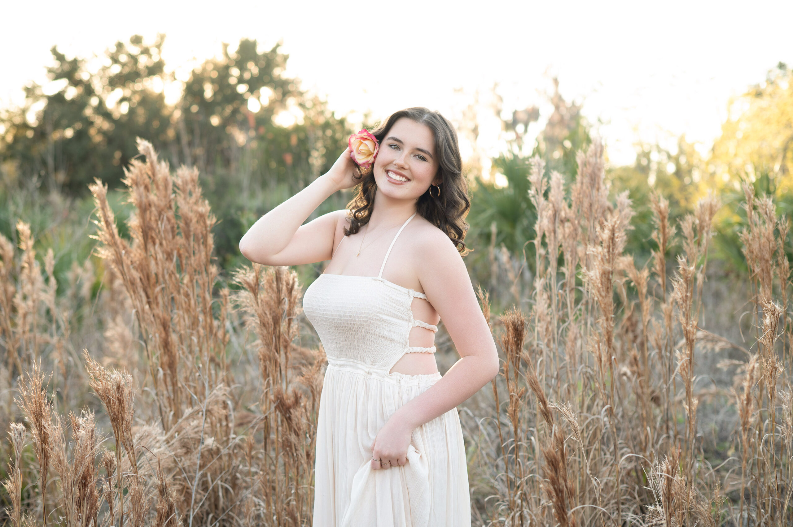 Senior girl in a field at golden hour.