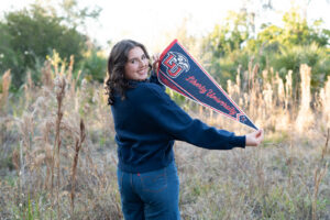 Timber Creek High School senior wearing her college t-shirt and holding her college flag during senior photos