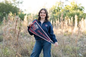 Senior girl from Timber Creek High School posing with college flag and t-shirt in Orlando